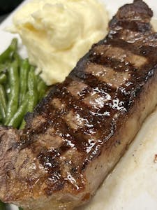 Order 12 oz. Dry-Aged New York Strip Steak food online from Bistro 1051 store, Clark on bringmethat.com