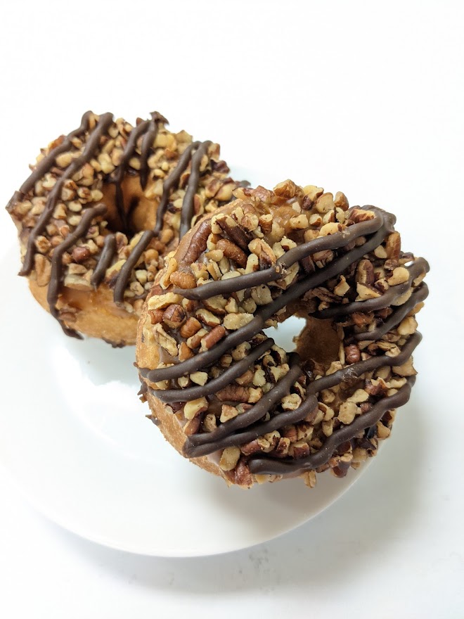 Order Yellow Cake Donut with Caramel Frosting ,Pecans and Chocolate Stripes  food online from Morkes Chocolate store, Huntley on bringmethat.com