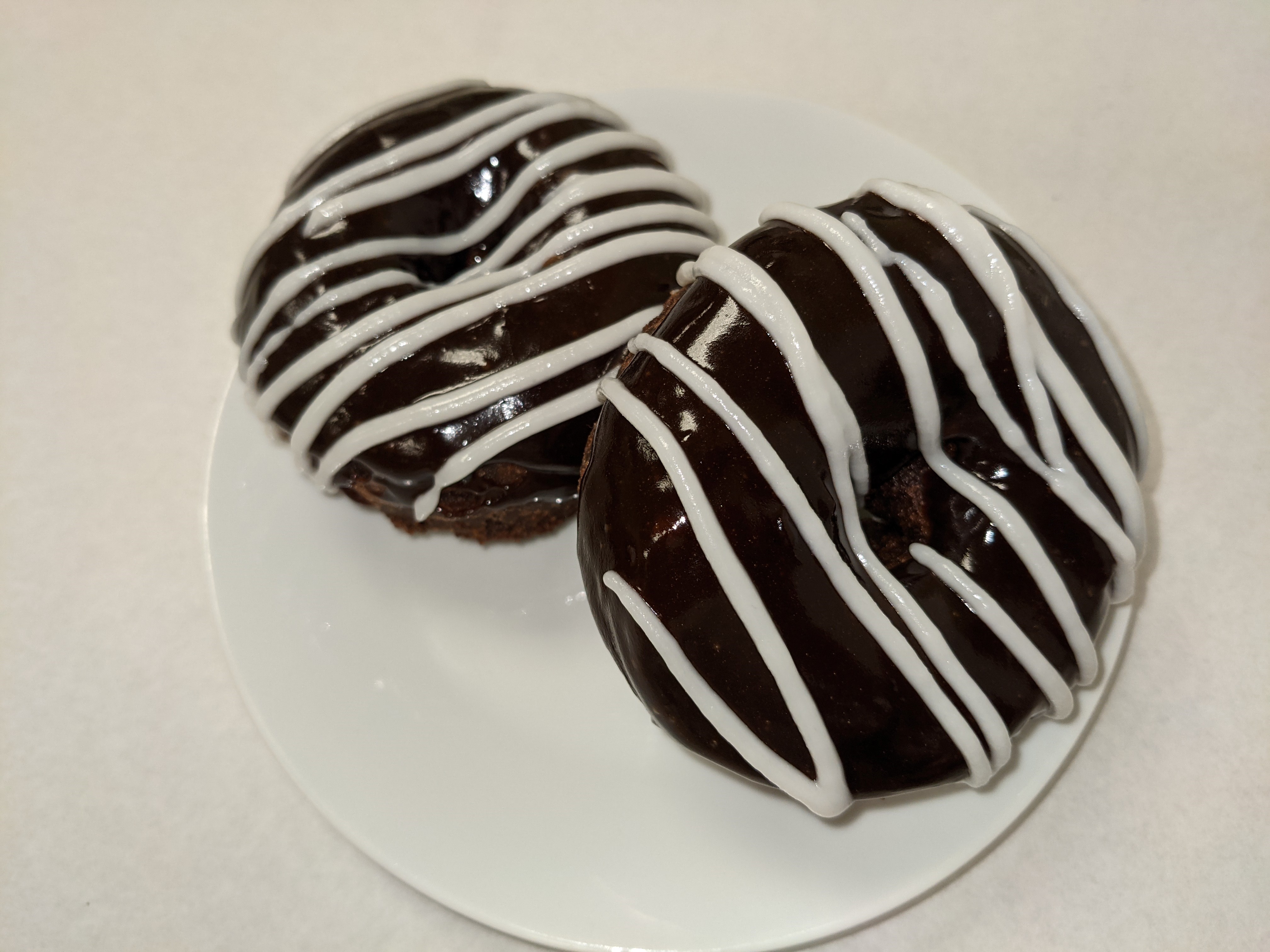Order Chocolate Cake Donut with Chocolate Frosting with White Frosting Stripes food online from Morkes Chocolate store, Huntley on bringmethat.com