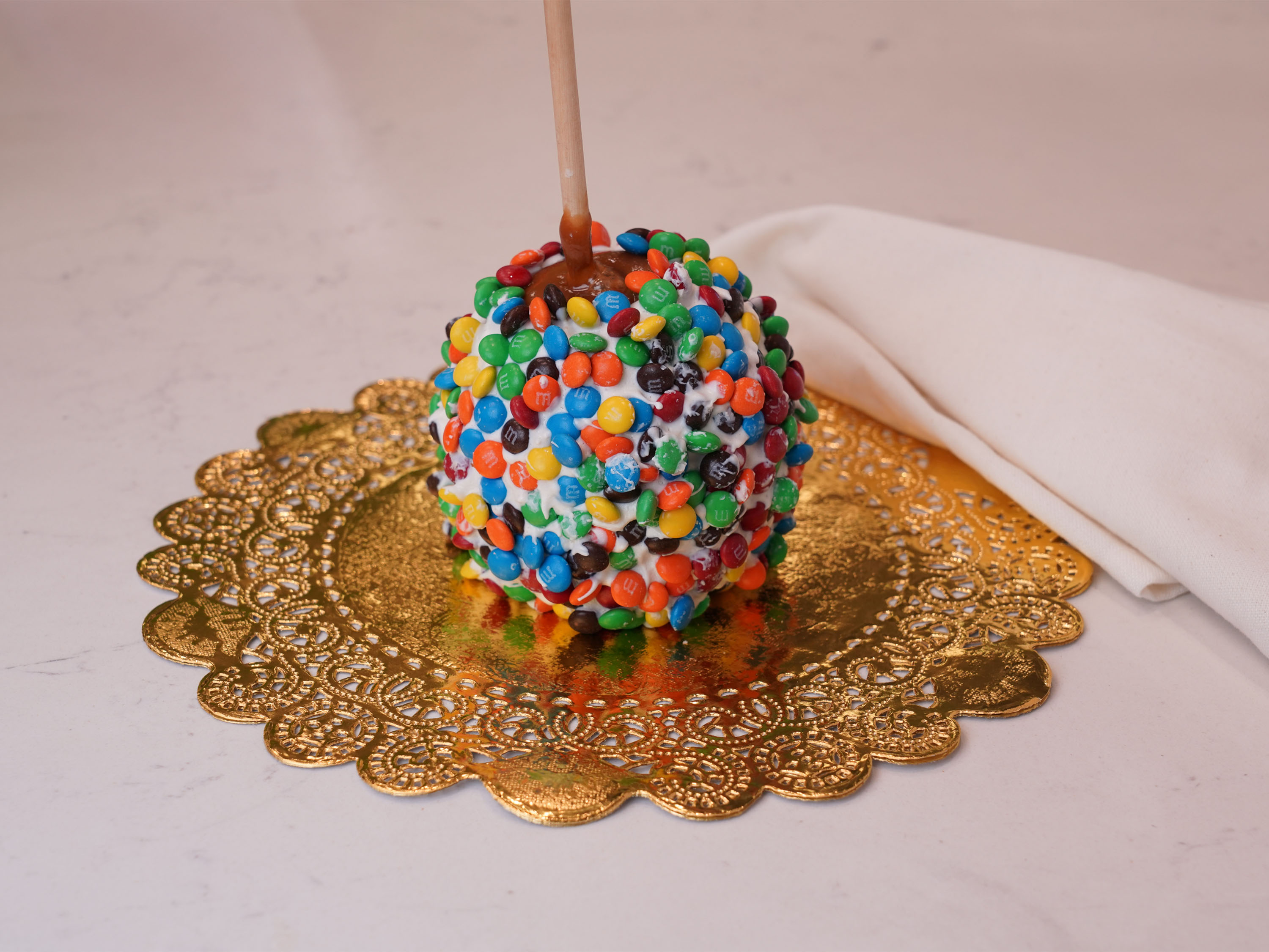 Order Rainbow M&M Caramel Apple food online from Chocolate Wishes And Treats store, Clovis on bringmethat.com