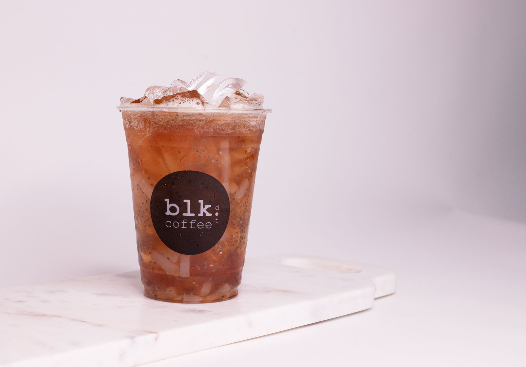 Order Iced Lychee Peach Black Tea food online from Blk Dot Coffee store, Laguna Beach on bringmethat.com