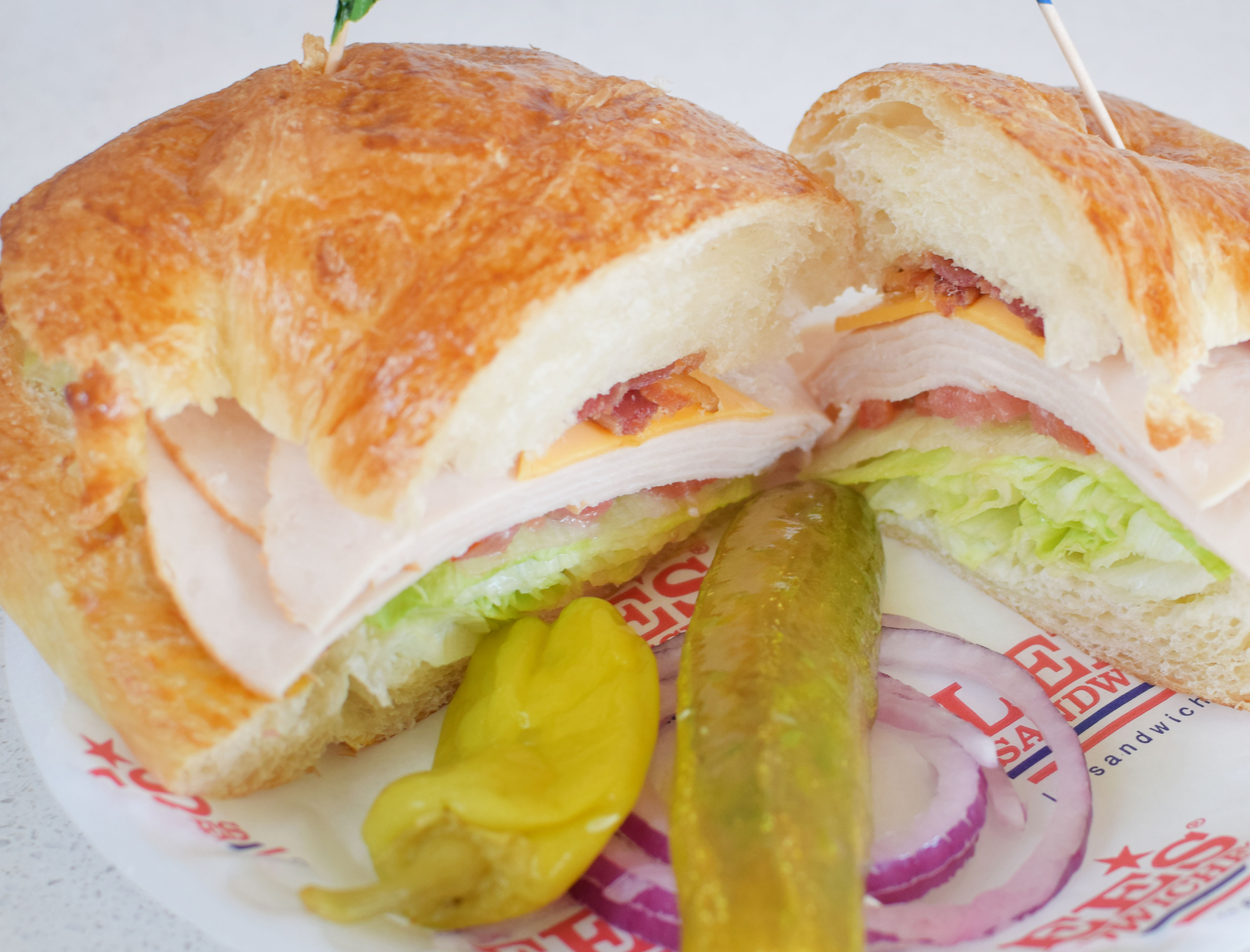 Order 67. Turkey Club with Croissant food online from Lee's Sandwiches store, Chino on bringmethat.com