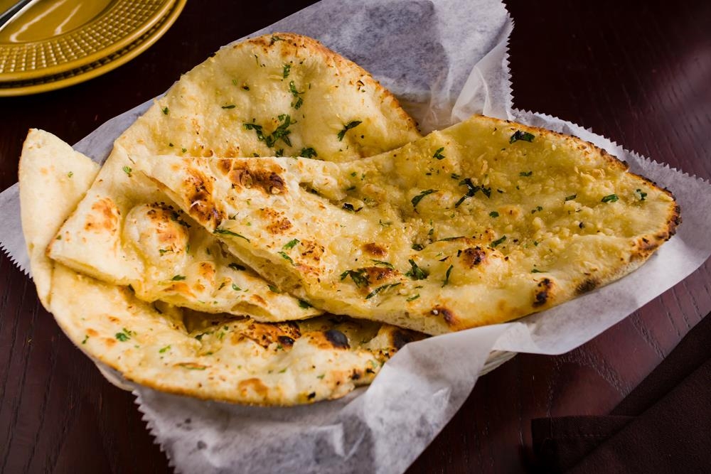 Order Garlic Naan food online from Dhaba indian cuisine store, New York on bringmethat.com