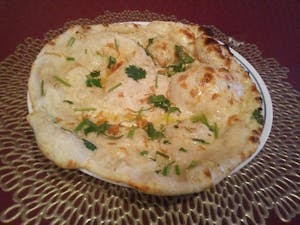 Order 104. Garlic Naan food online from New Taj Mahal Indian Restaurant store, Columbus on bringmethat.com