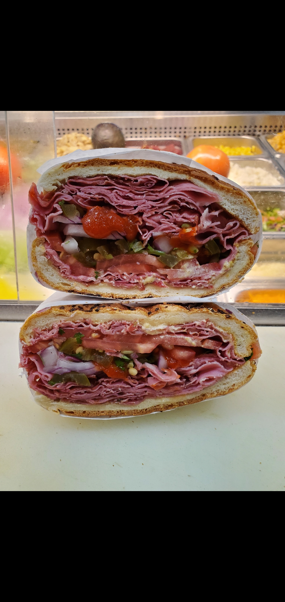 Order Boar's Head Pastrami Melted Swiss Red Onions Jalapeños Peppers Tomatoes & Sriracha Chili Sauce  food online from American Gourmet Foods Deli store, New York on bringmethat.com