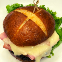 Order Ham and Swiss Pretzel with Caramelized Onion Jam Sandwich food online from Simply Vanilla Gourmet store, Lynchburg on bringmethat.com