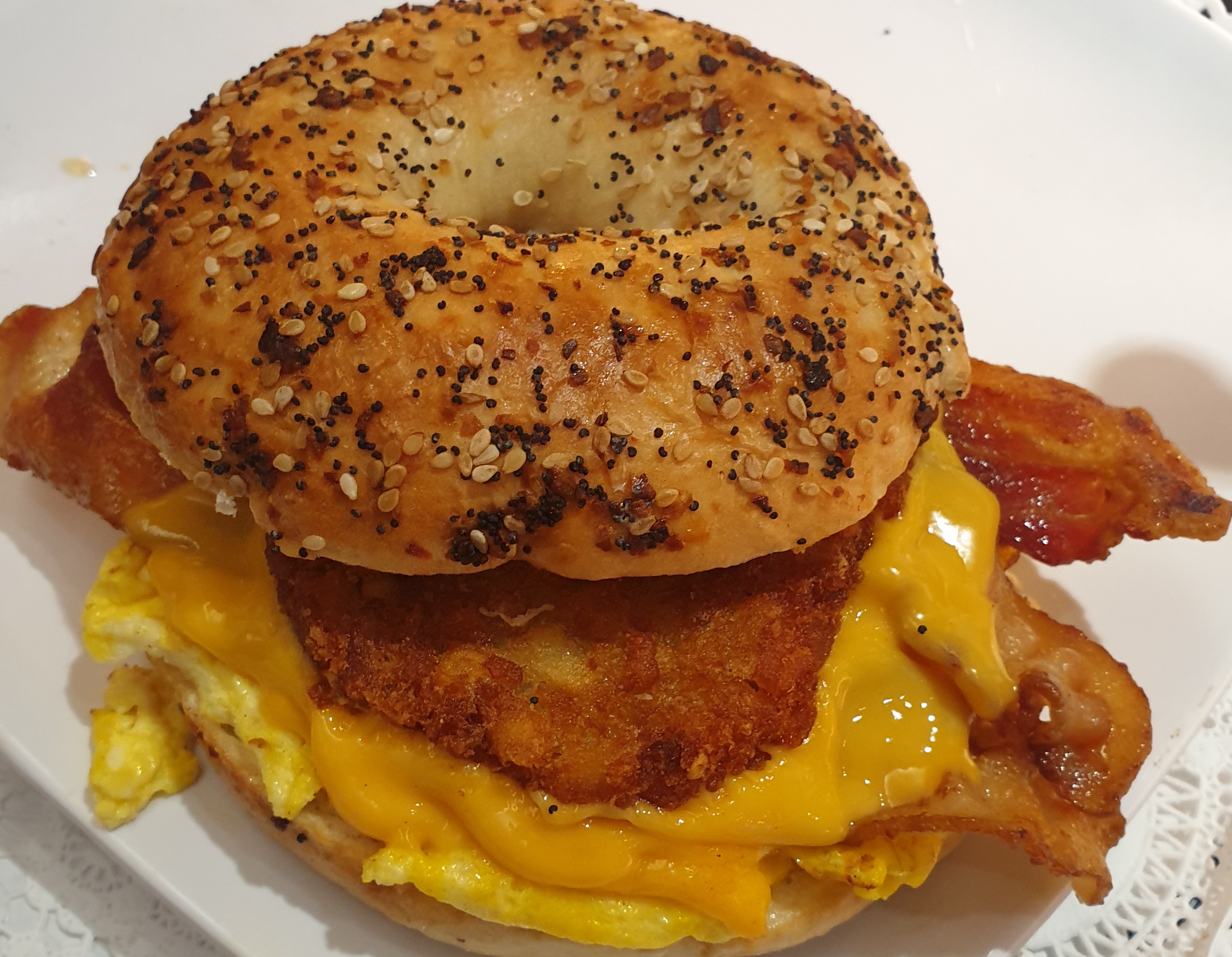 Order 2 Eggs Bacon Cheese & Hash brown Patty on a Toasted Everything Bagel food online from Taz Cafe store, New York on bringmethat.com