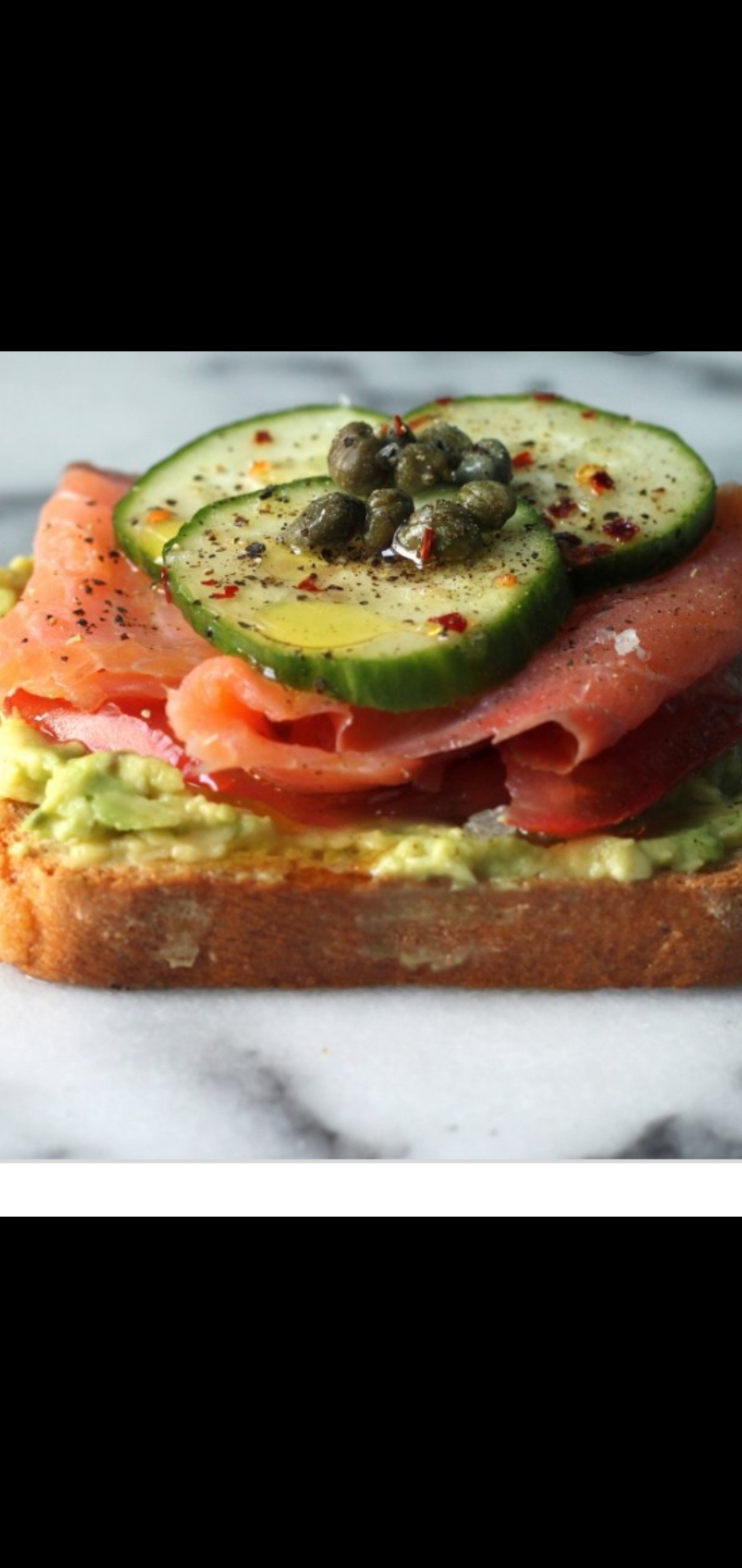 Order Avocado Toast Topped With Nova Smoked Salmon,Cucumbers & Capers (two slices open face) food online from American Gourmet Foods Deli store, New York on bringmethat.com