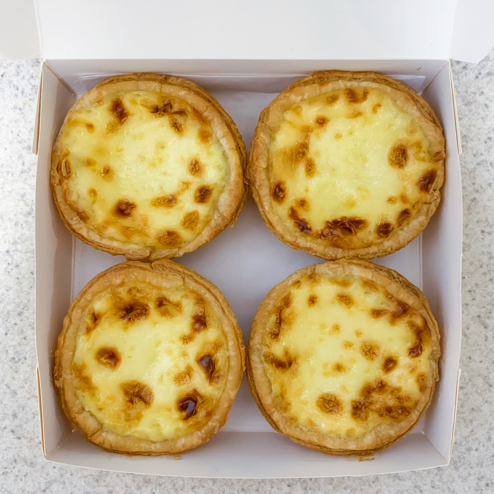 Order Portuguese Egg Tart Box (4) food online from Chew Chew Bun store, State College on bringmethat.com
