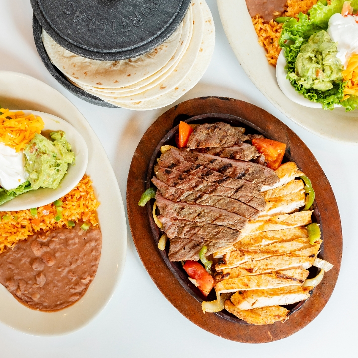 Order Sizzling Chicken Fajitas For Two food online from El Fenix Mexican Restaurant store, Greenville on bringmethat.com
