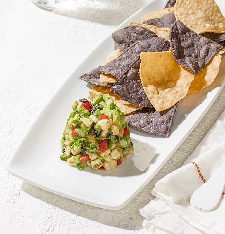 Order WHITE CORN GUACAMOLE + CHIPS food online from California Pizza Kitchen store, Tustin on bringmethat.com