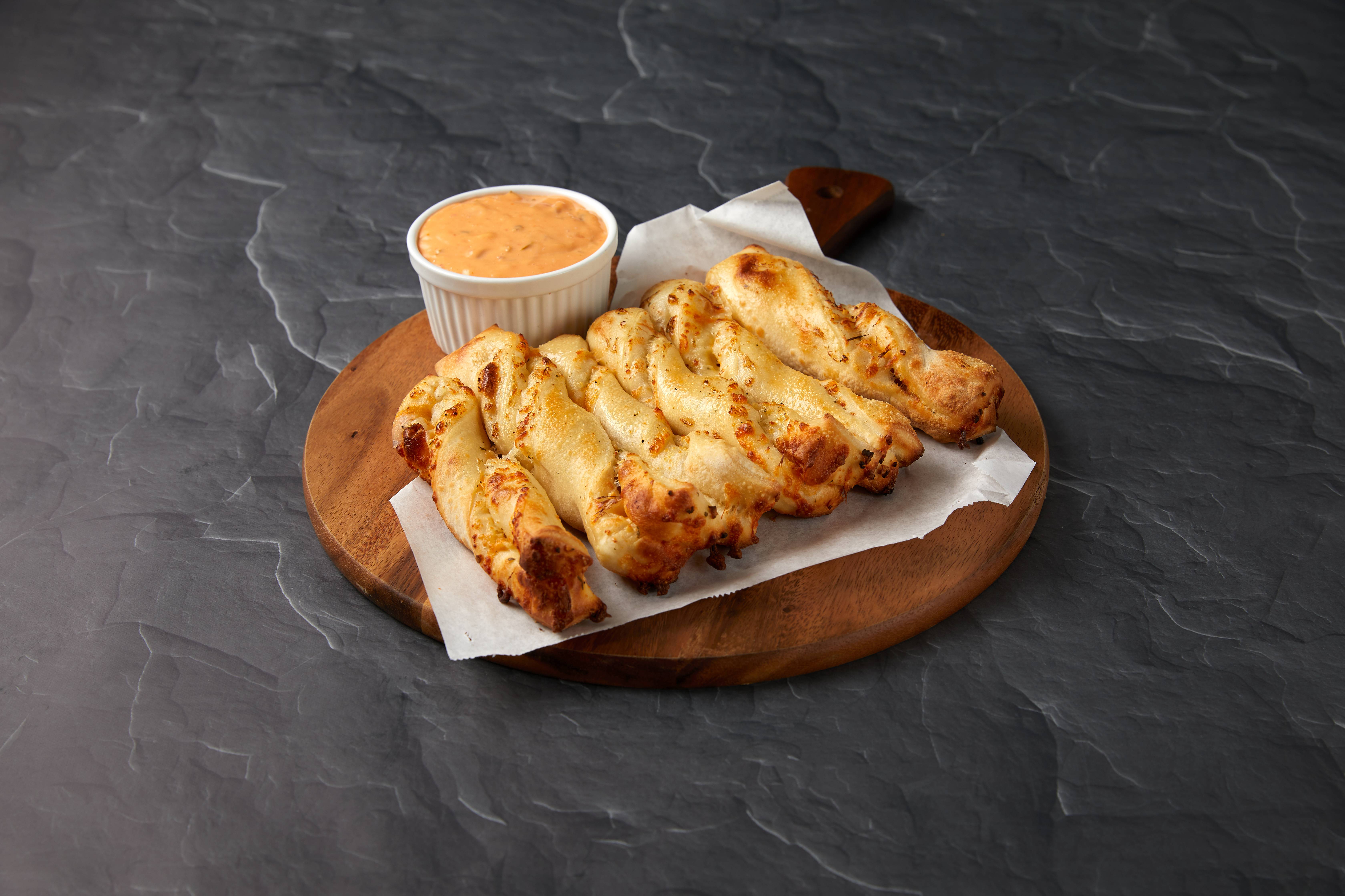 Order Garlic Parmesan Twists food online from Round Table Pizza store, Las Vegas on bringmethat.com