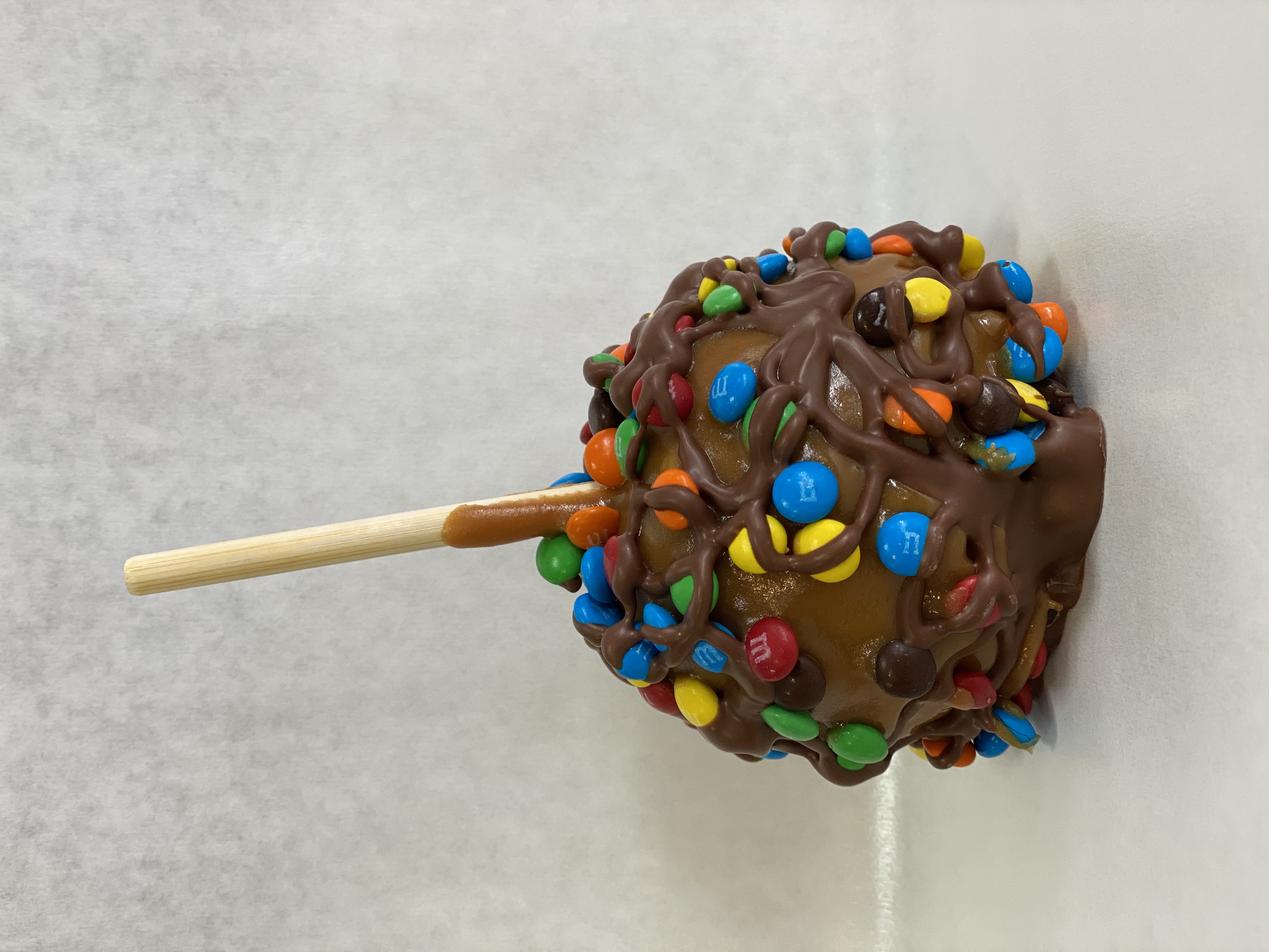 Order M&M's® Caramel Apple food online from Rocky Mountain Chocolate Factory store, Irvine on bringmethat.com