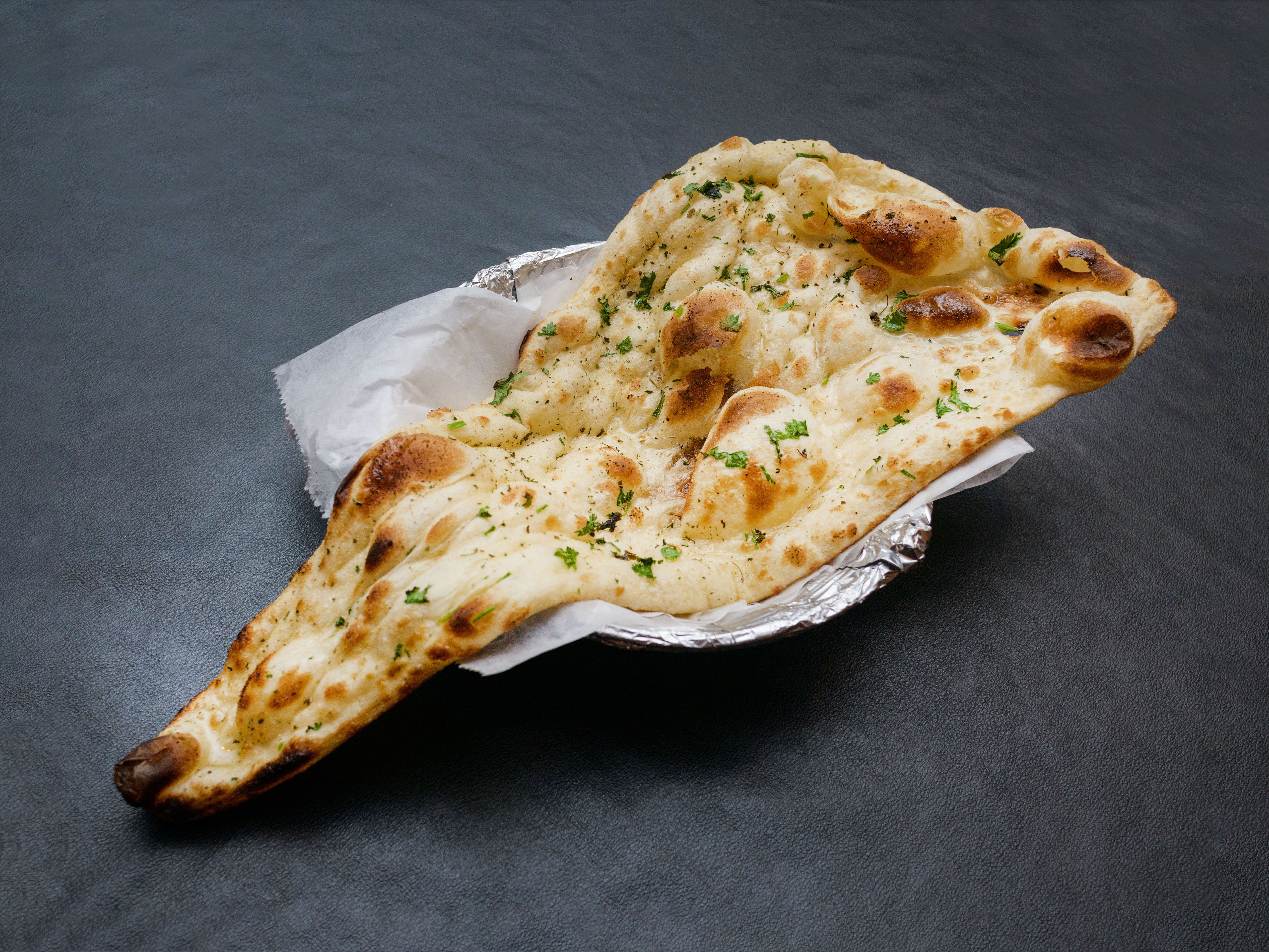 Order Garlic Naan food online from House of India store, Loves Park on bringmethat.com