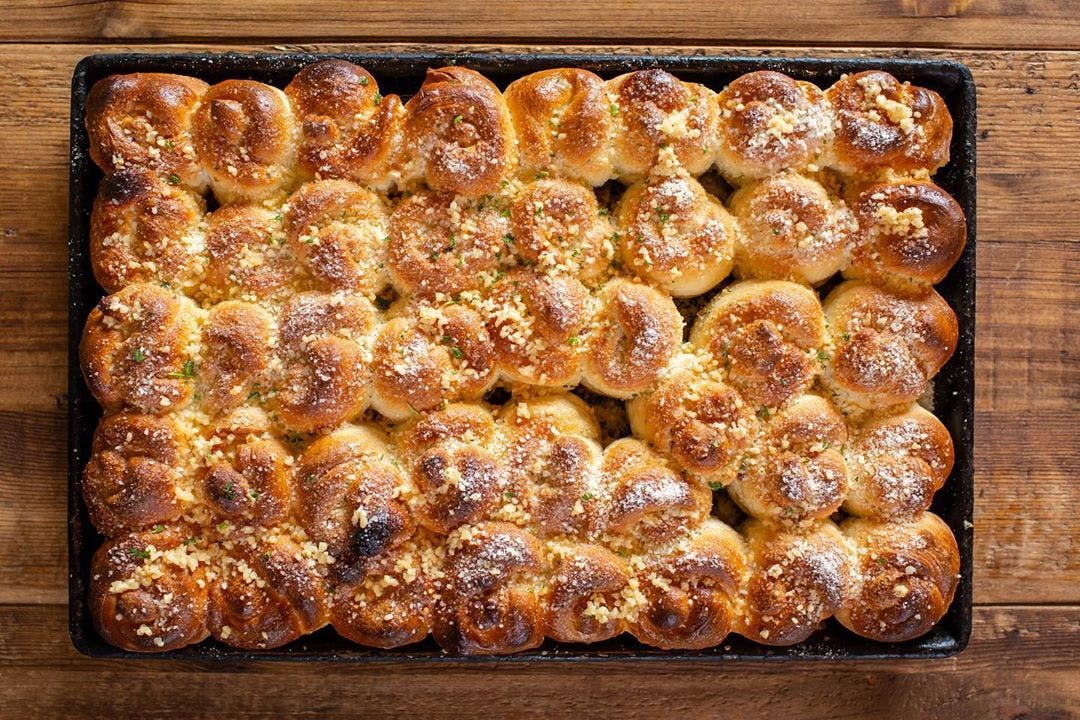 Order House Baked Garlic Knots Catering - Half Tray (Serves 8-10 People) food online from Cosimos Pizza Cafe store, Philadelphia on bringmethat.com