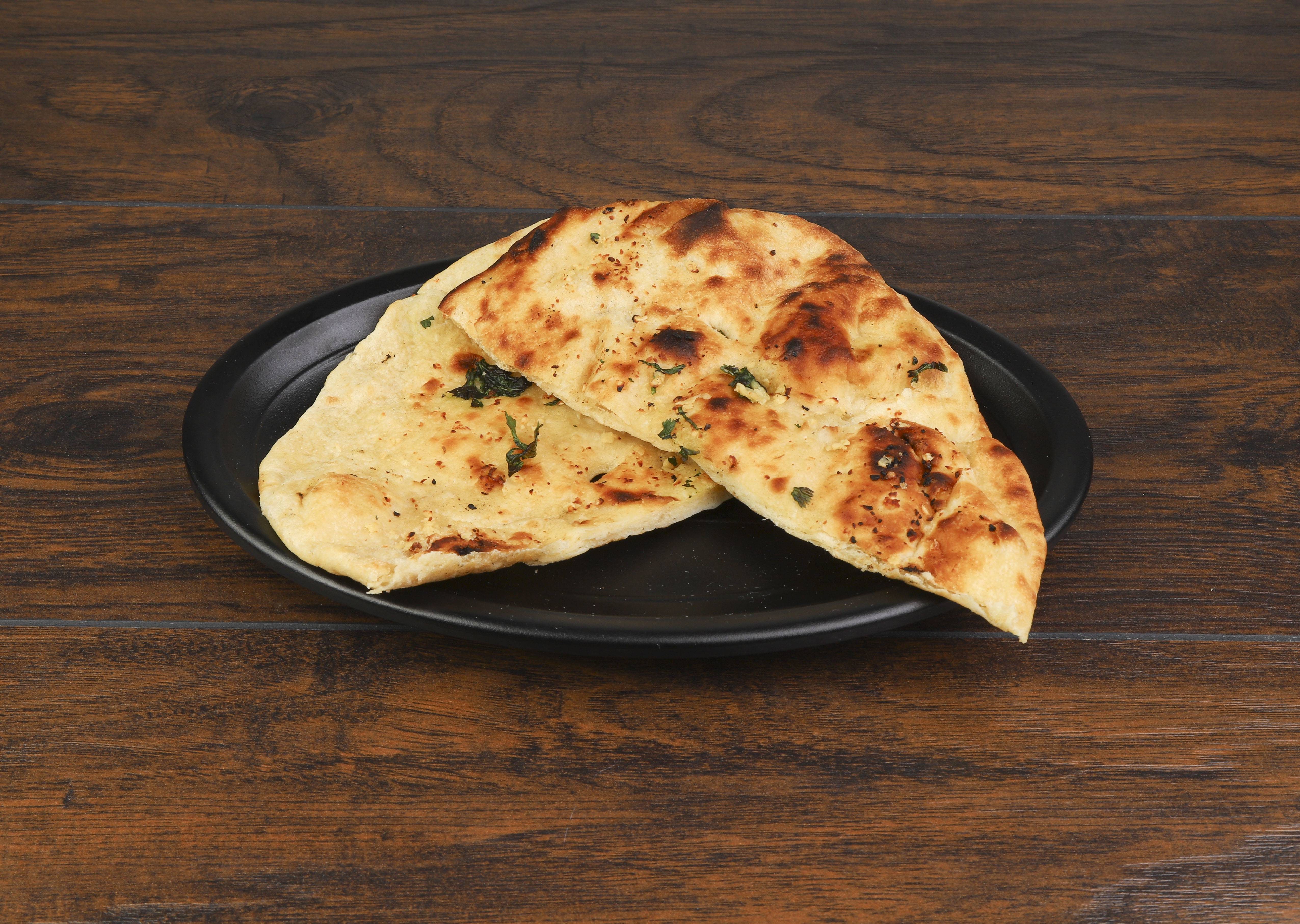 Order 11. Garlic Naan food online from Amol India Carryout Restaurant store, Newport on bringmethat.com