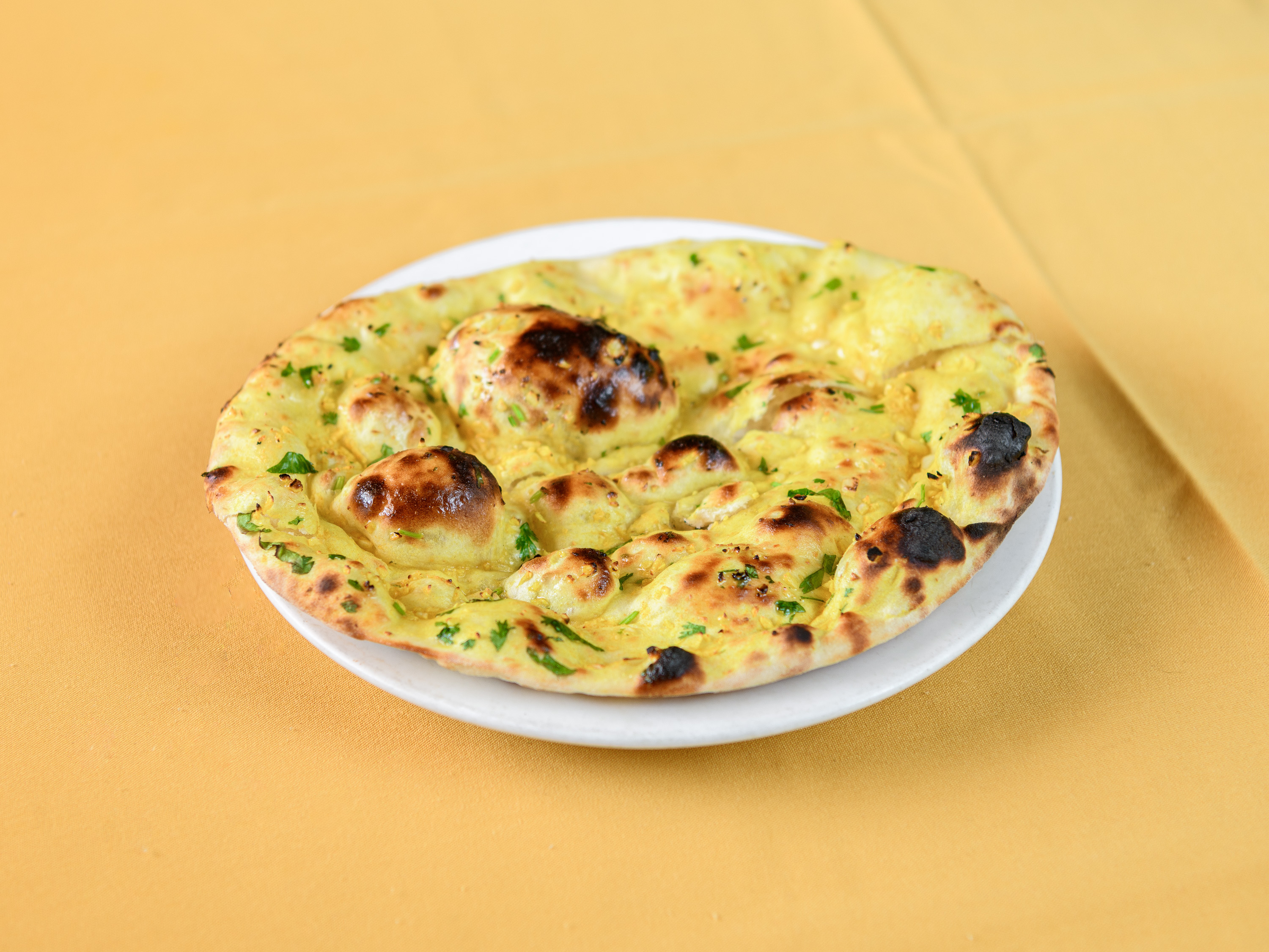 Order Garlic Tandoori Naan food online from Taj Cuisine of India store, Oklahoma City on bringmethat.com