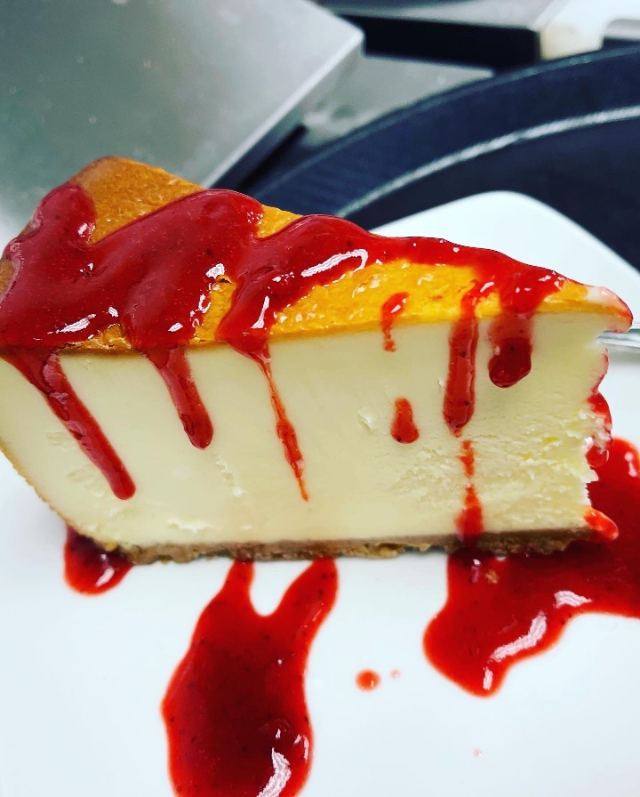 Order New York Cheese Cake with Strawberry Drizzle  food online from Tlc On The Lake store, Garland on bringmethat.com
