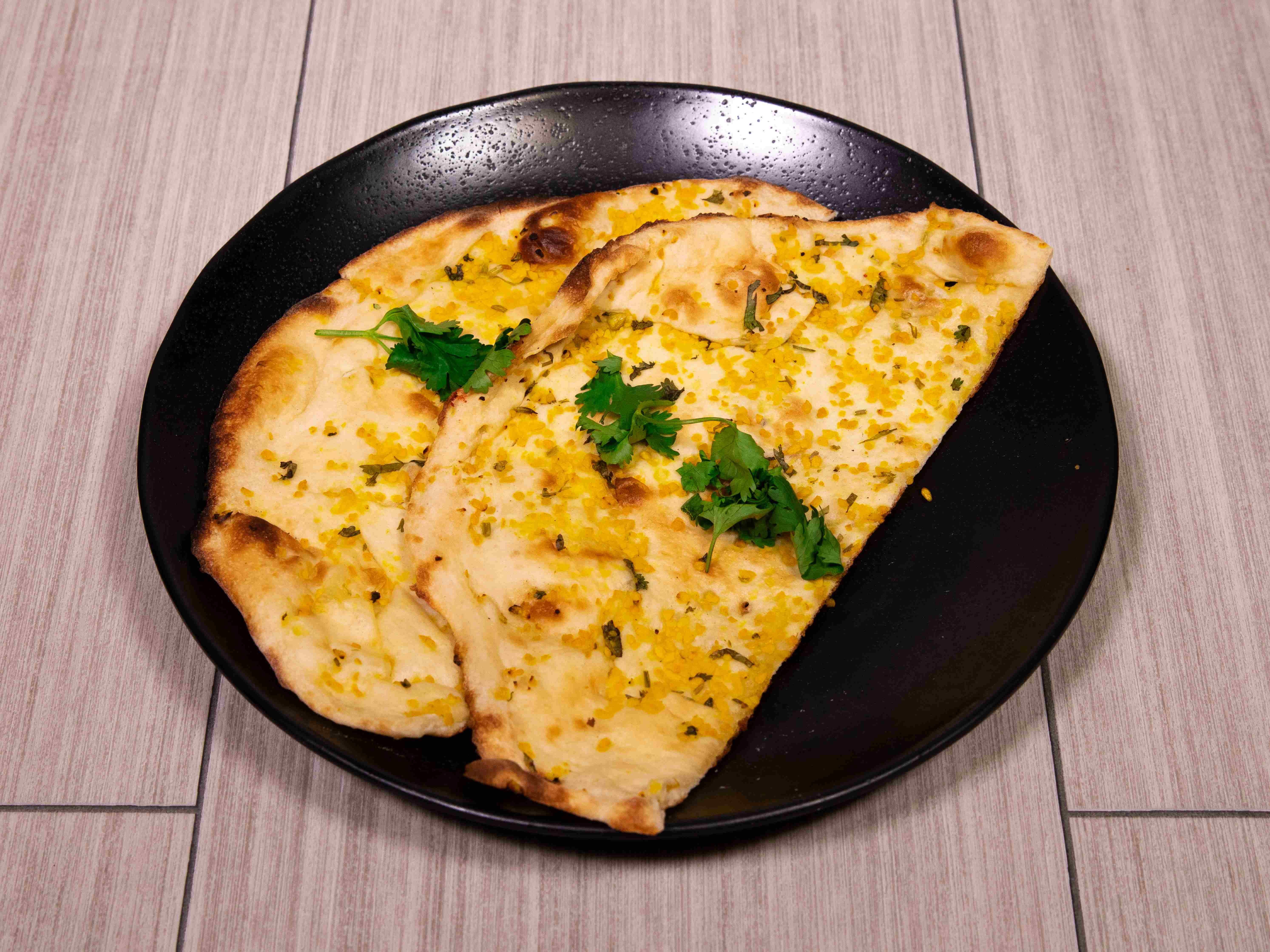 Order Garlic Naan food online from Tikka N Kabab store, Dallas on bringmethat.com