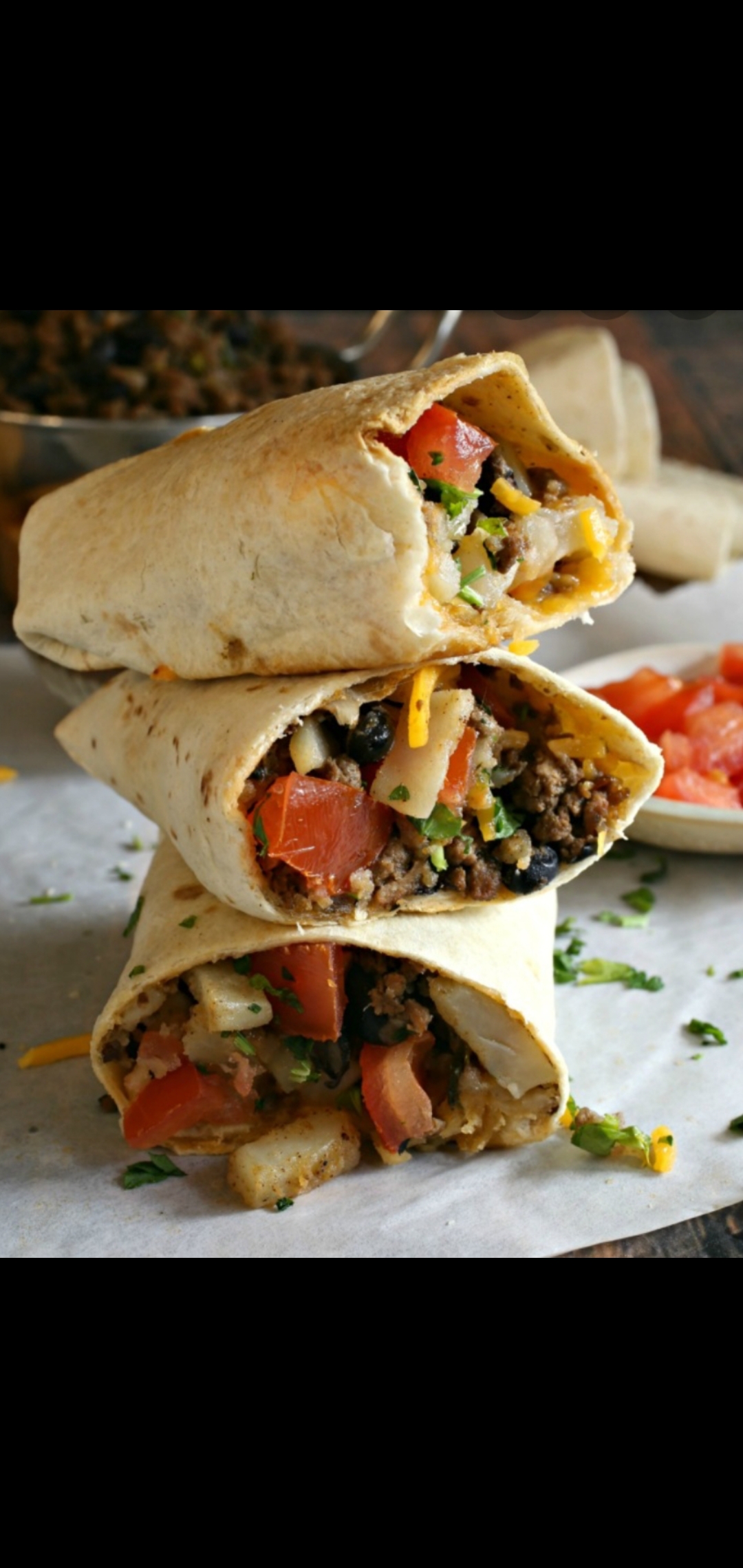 Order Tex-Mex Potato & Beef Burrito (lean ground beef potatoes onions cumin garlic jalapeños black beans cilantro tomatoes & cheddar cheese) food online from American Gourmet Foods Deli store, New York on bringmethat.com