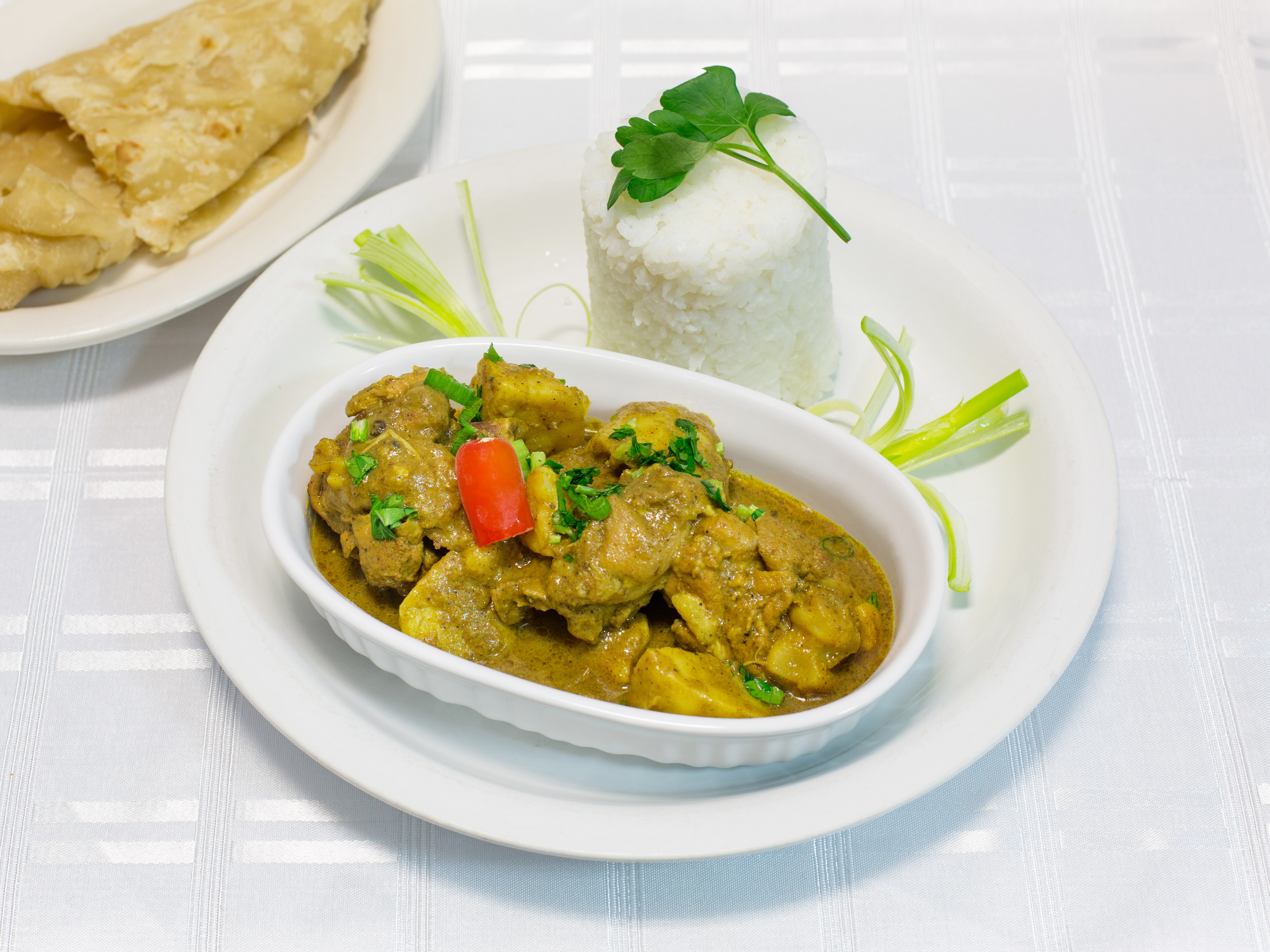 Order 39. Chicken Curry served with white rice, rice and beans or roti food online from Caribbean Essence store, Belleville on bringmethat.com