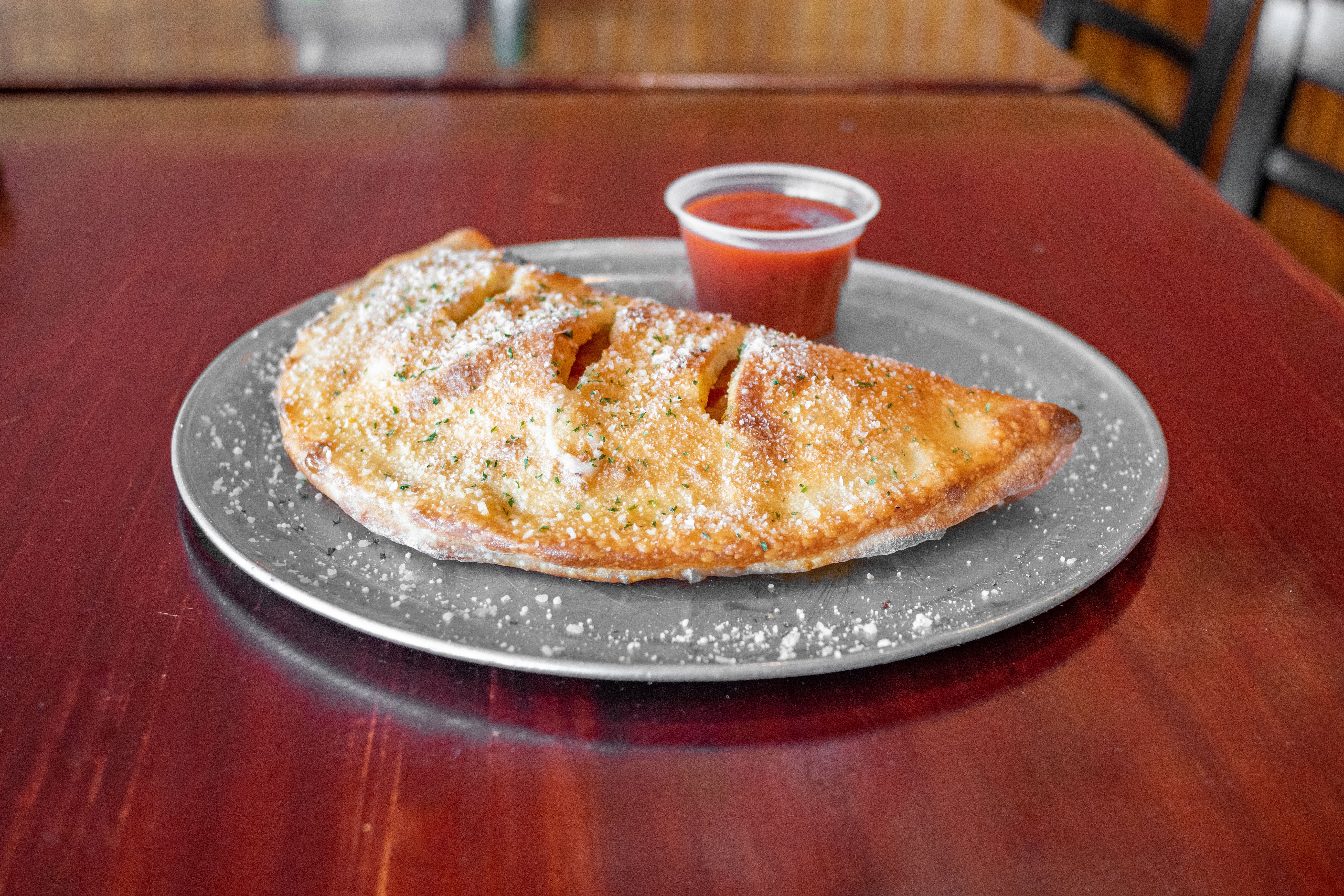 Order Calzone with Two Toppings - Medium food online from Julia's Pizza store, Orlando on bringmethat.com