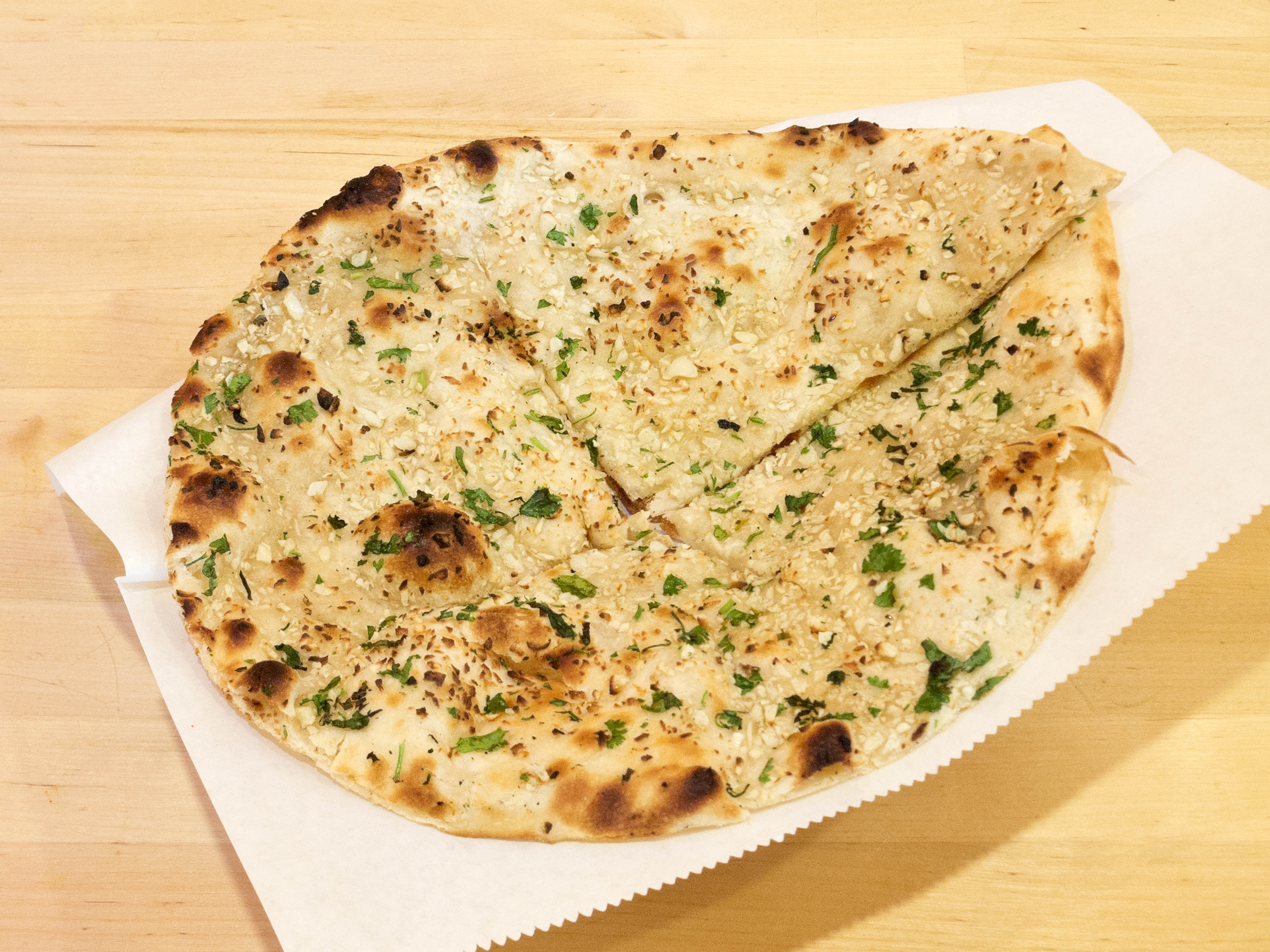 Order E3. Garlic Naan food online from Mela Indian Cuisine store, Fort Worth on bringmethat.com
