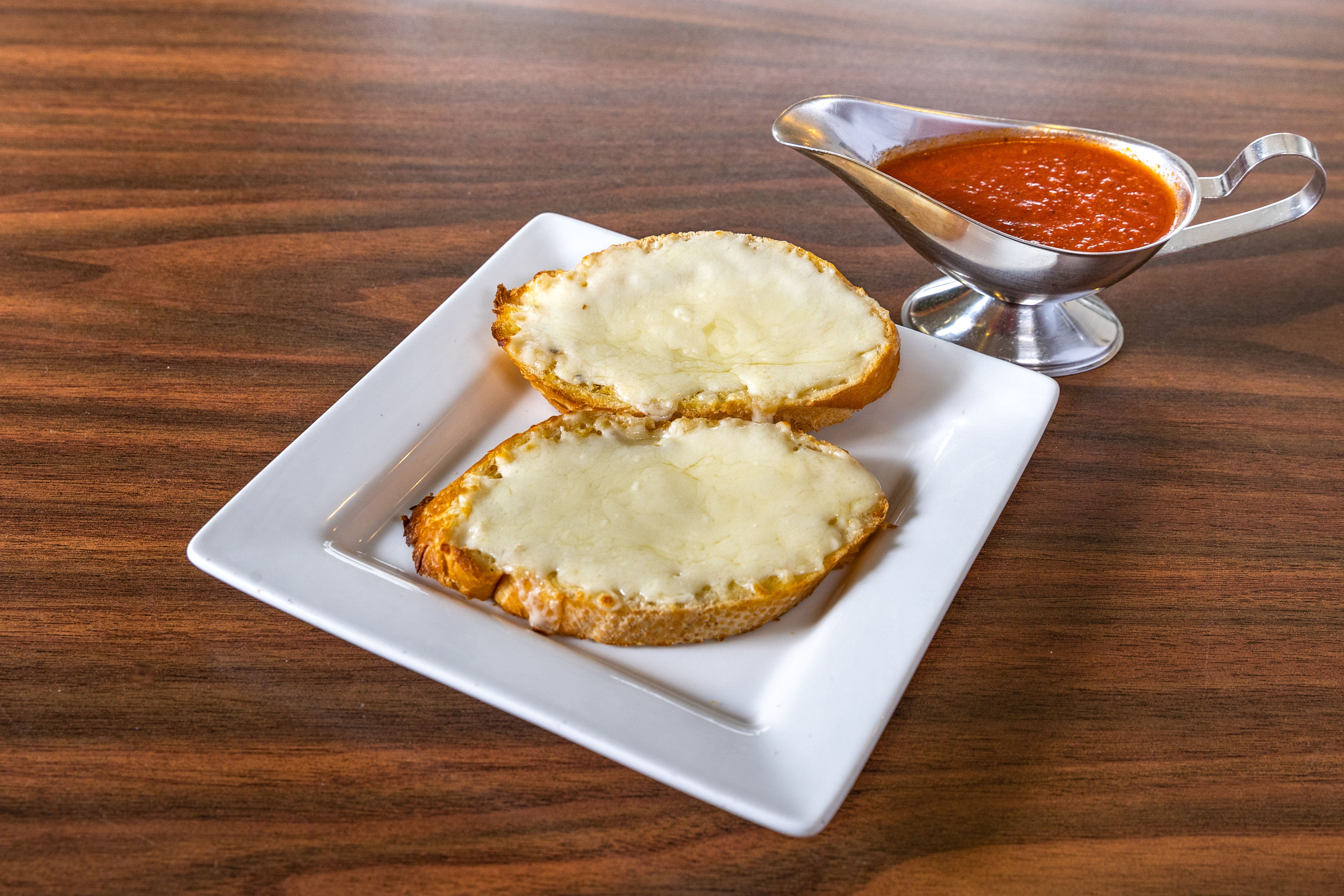 Order Garlic Bread with Cheese - Appetizers food online from Serafini's Pizzeria store, Brighton on bringmethat.com