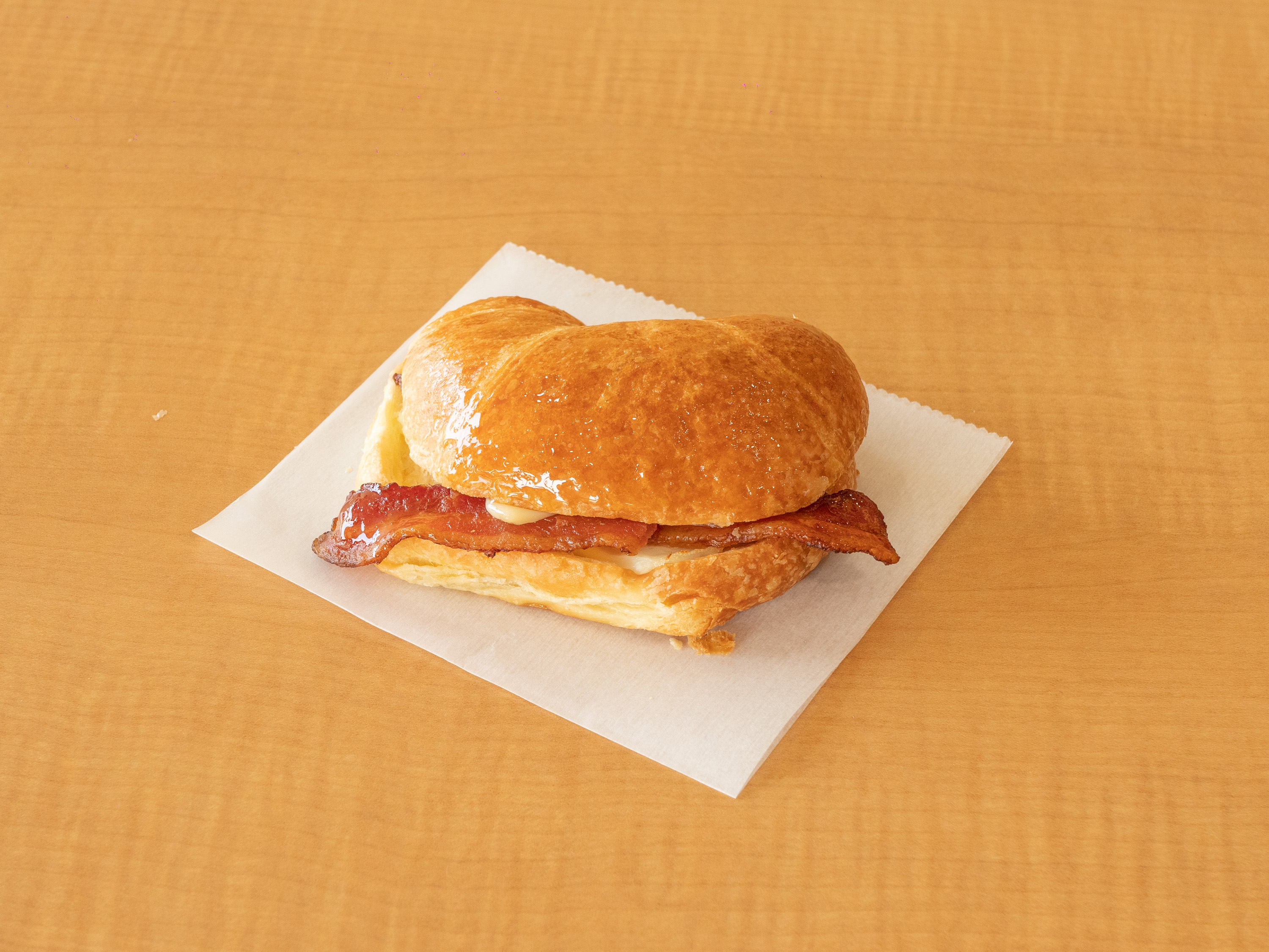 Order Bacon and Cheese Croissant Sandwich food online from Sara Donuts store, Euless on bringmethat.com