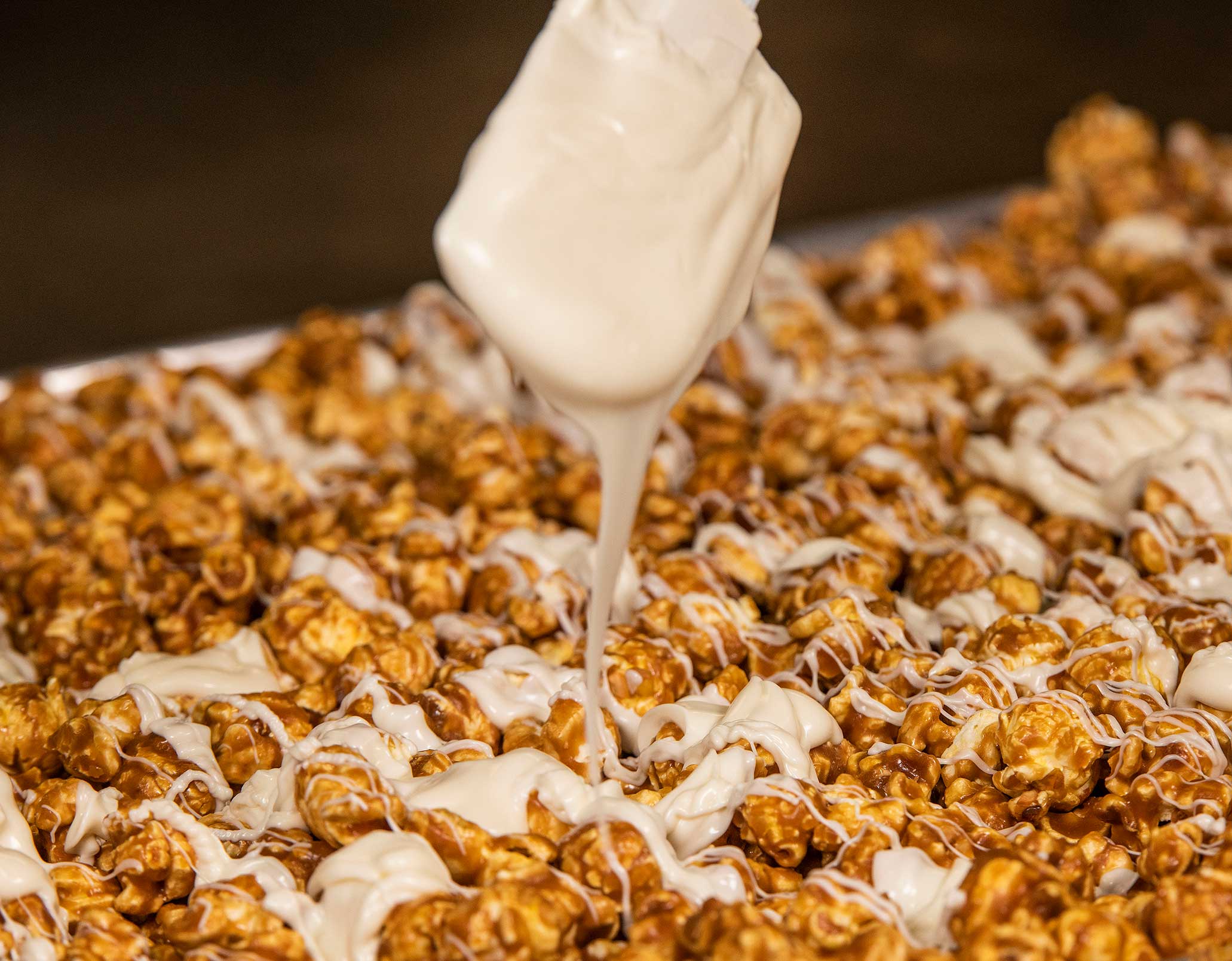 Order Caramel drizzled with White Chocolate food online from Popus Gourmet Popcorn store, Joliet on bringmethat.com