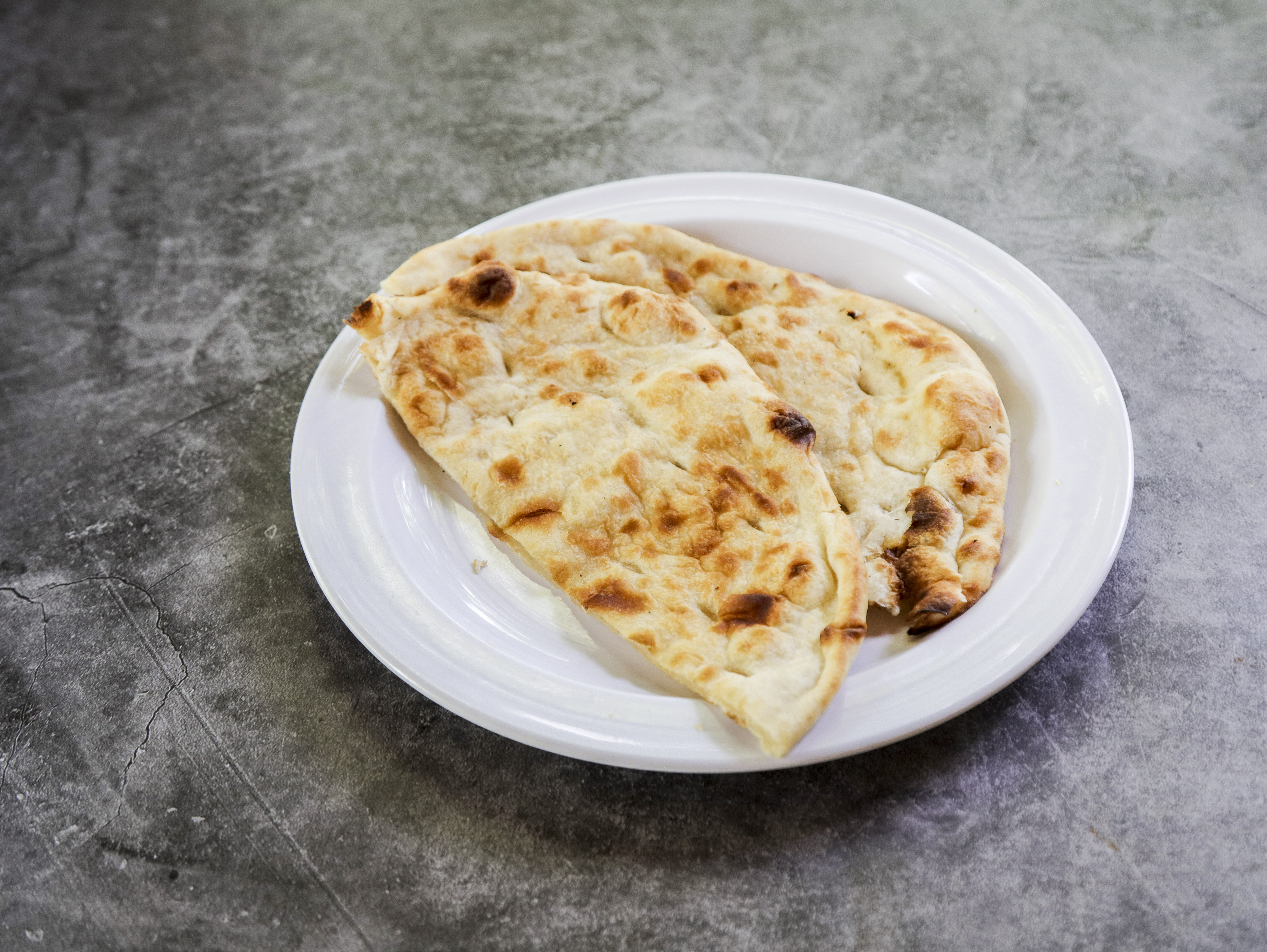 Order 19. Naan food online from Ambar Indian Restaurant store, Champaign on bringmethat.com