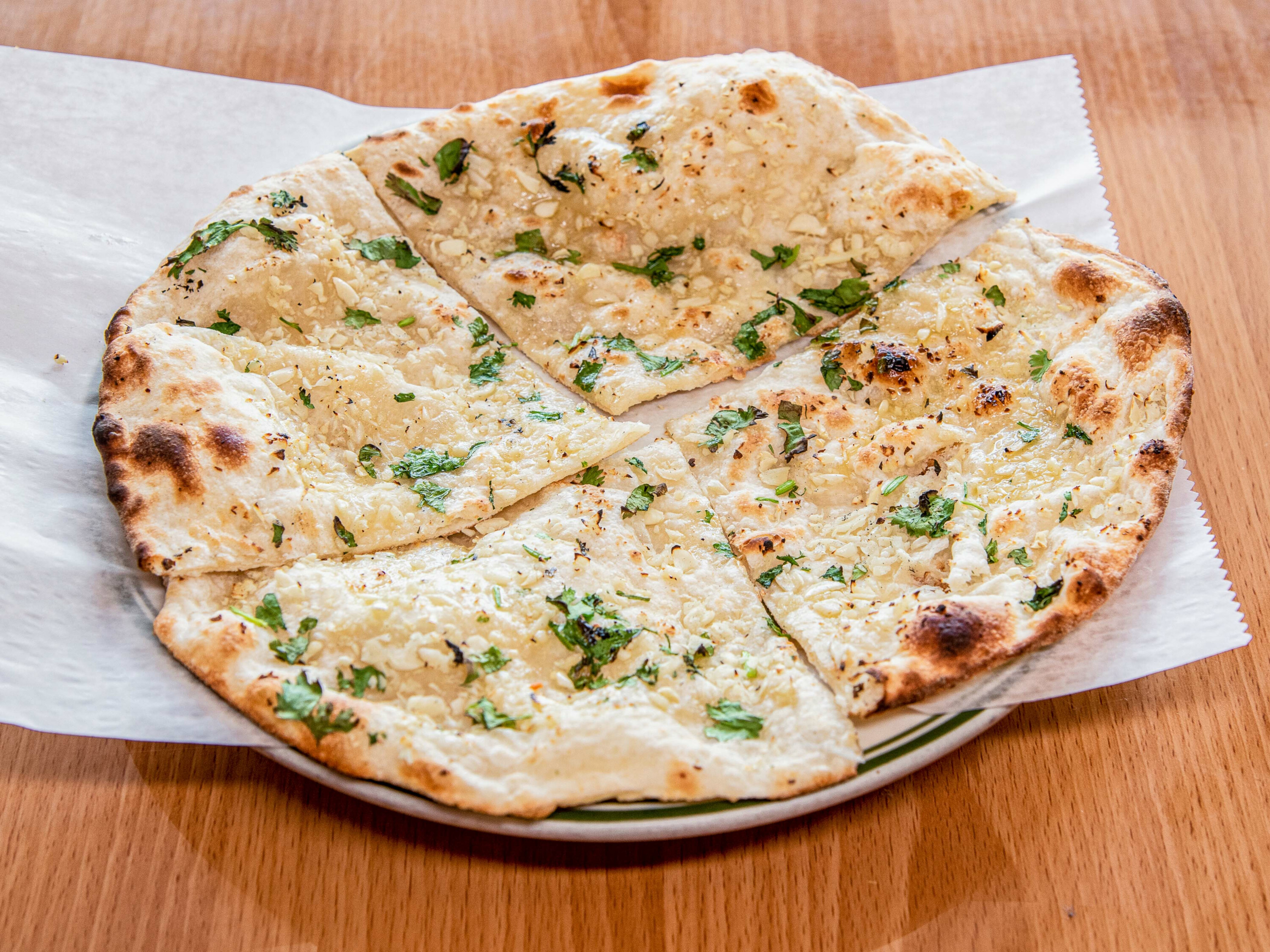 Order 16. Garlic Naan food online from India House Restaurant store, Michigan City on bringmethat.com
