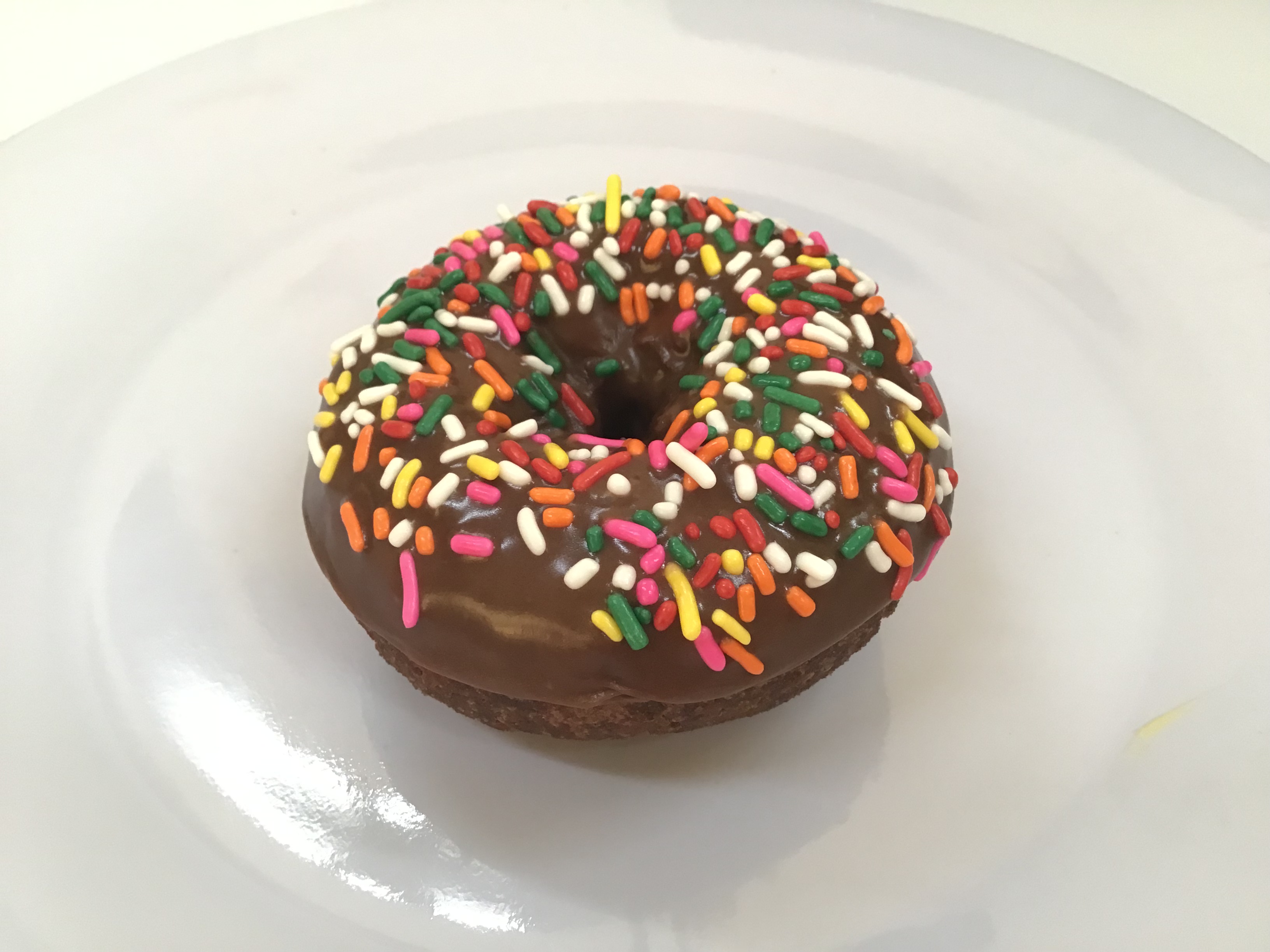 Order Chocolate Devil Food with Rainbow Sprinkle Donut food online from Donut Basket store, Modesto on bringmethat.com