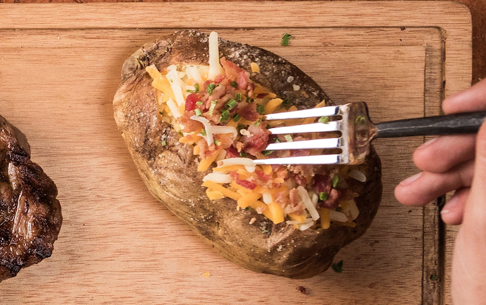 Order Baked potato food online from Great American Steakhouse store, El Paso on bringmethat.com