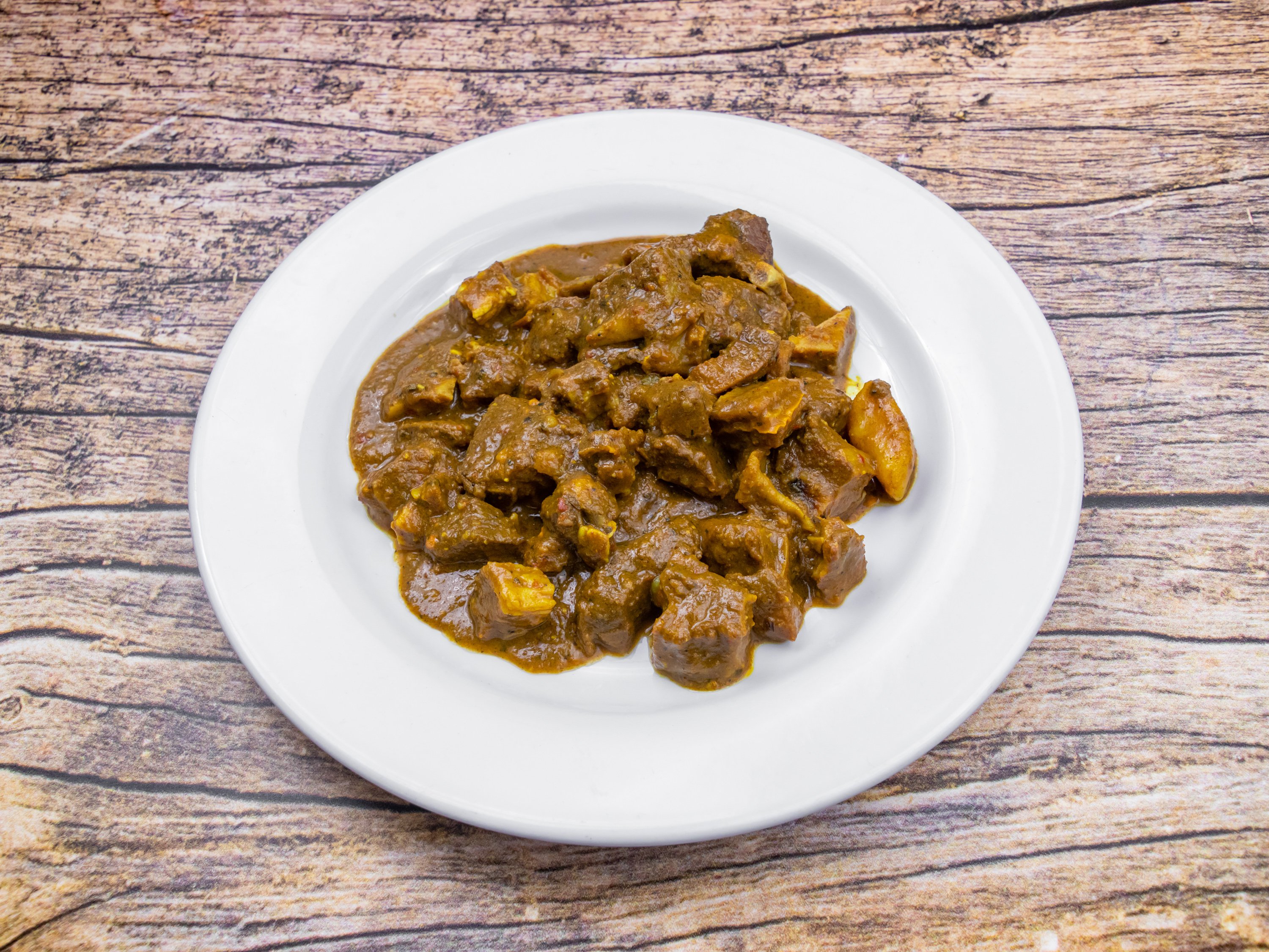 Order Curry Goat food online from Lyons Jamaican Cuisine Llc store, Norcross on bringmethat.com