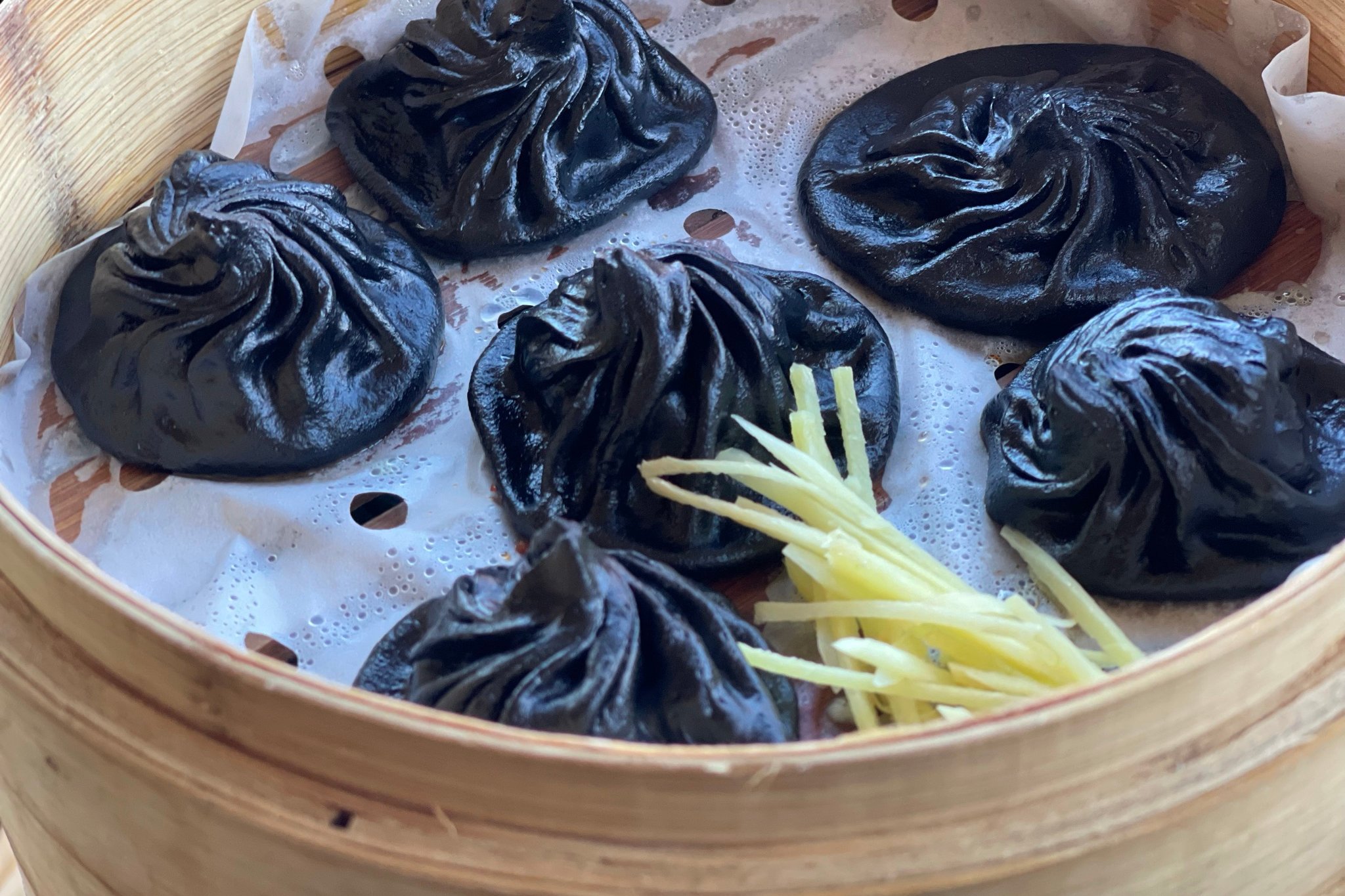 Order Black Malat Chili Oil Pork Soup Dumpling made with Squid ink ＆ charcoal - Xiao Long Bao food online from Iron Teapot Dim Sum store, Los Angeles on bringmethat.com