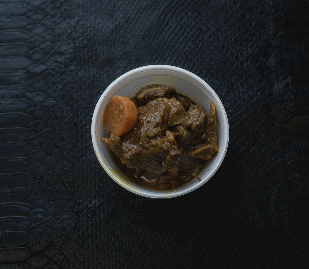 Order CURRY GOAT food online from Yard Cooked Dishes store, Charlotte on bringmethat.com