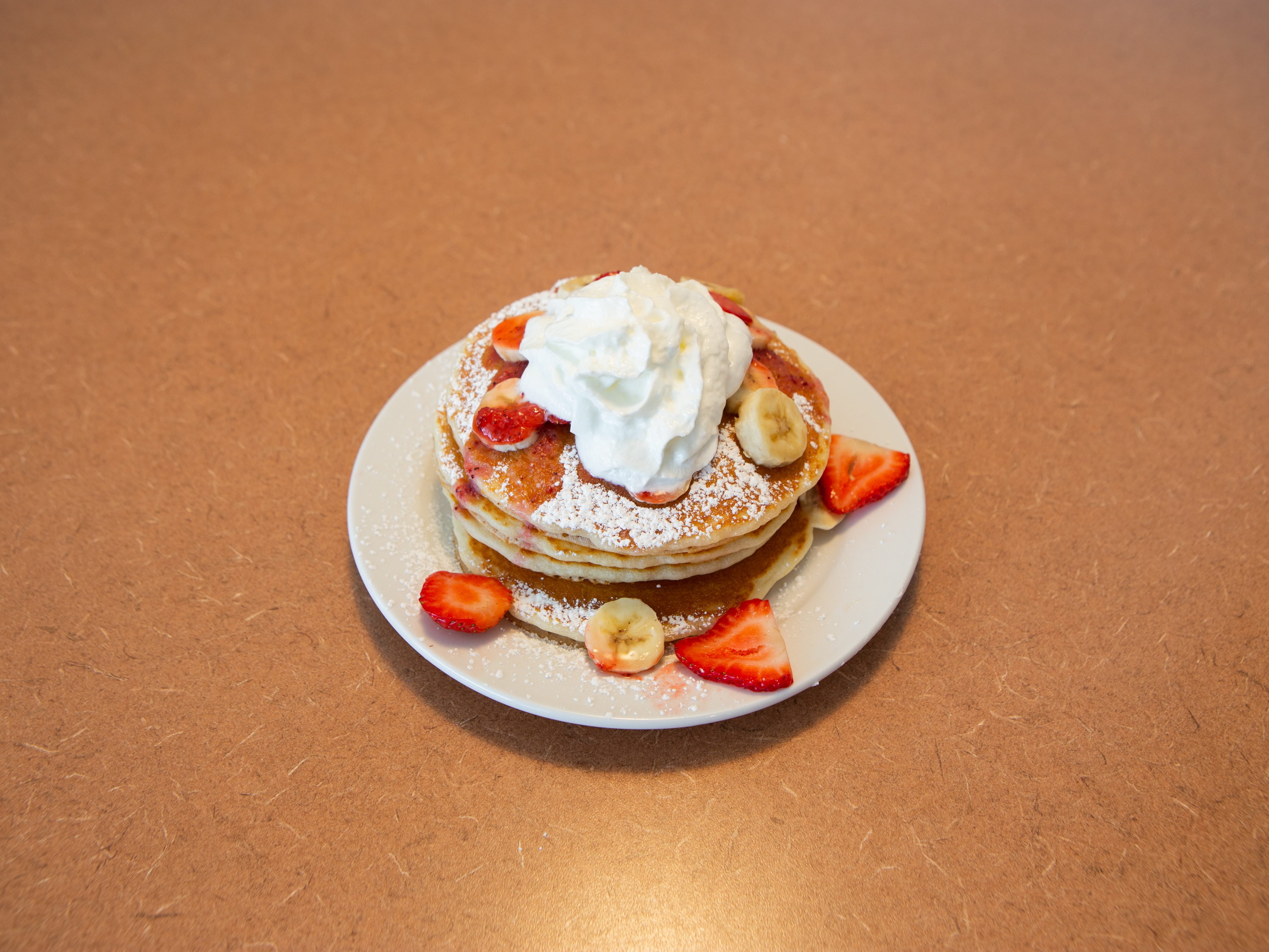 Order Strawberry Banana Pancakes Breakfast food online from Ely's Restaurant store, Henderson on bringmethat.com